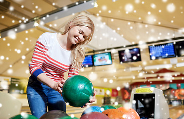 Image showing happy young woman holding ball in bowling club