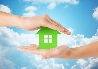 Image showing close up of woman hands holding green house