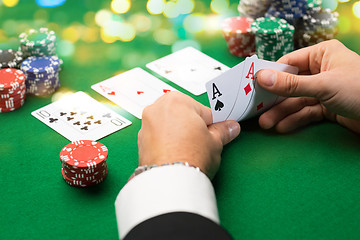 Image showing poker player with cards and chips at casino