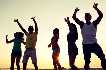 Image showing smiling friends dancing on summer beach