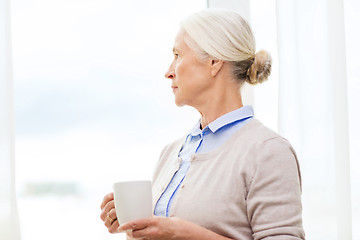 Image showing lonely senior woman with cup of tea or coffee