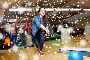 Image showing happy young woman throwing ball in bowling club