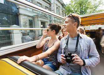 Image showing smiling couple with camera traveling by tour bus