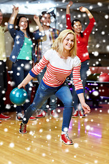 Image showing happy young woman throwing ball in bowling club