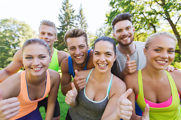 Image showing group of happy sporty friends showing thumbs up