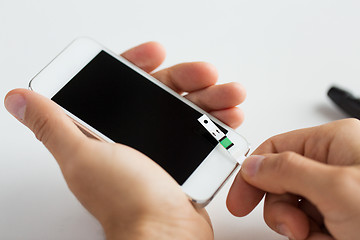 Image showing close up of man with smartphone making blood test