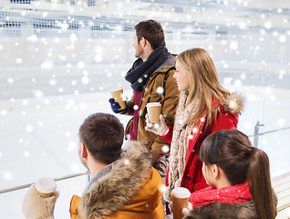 Image showing happy friends with coffee cups on skating rink