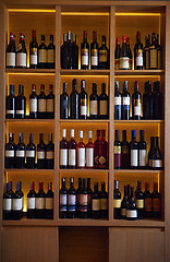 Image showing Wine bottles on a wooden shelf.