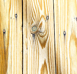 Image showing nail dirty stripped paint in the brown wood door and rusty  yell