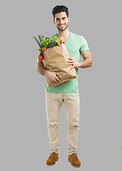 Image showing Man carrying a bag full of vegetables