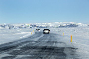 Image showing Snowy and icy road with volcanic mountains in wintertime