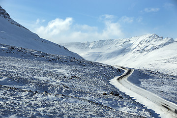 Image showing Snowy and icy road with volcanic mountains in wintertime