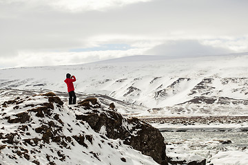 Image showing Hiker at mountain top of waterfall Godafoss