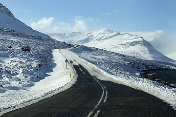 Image showing Snowy and icy road with volcanic mountains in wintertime