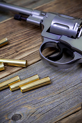 Image showing Nagan revolver with cartridges on wood boards