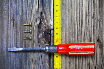 Image showing old screwdriver, three screws and measuring tape 