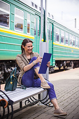 Image showing woman takes notes in notepad and laughing