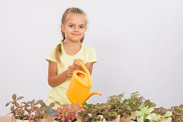 Image showing Six-year girl watering potted plants