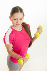 Image showing Girl athlete with two dumbbells