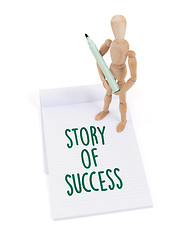 Image showing Wooden mannequin writing - Story of success