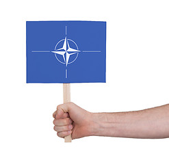 Image showing Hand holding small card - Flag of NATO