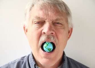 Image showing man with earth model in his mouth 