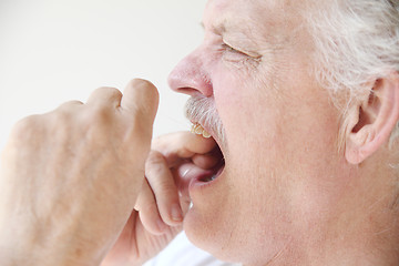 Image showing older man flossing teeth profile view 