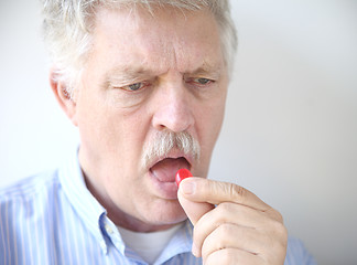 Image showing senior man with cough drop