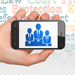 Image showing Law concept: Hand Holding Smartphone with Business Team on display