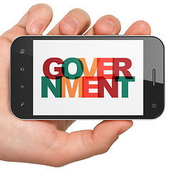 Image showing Politics concept: Hand Holding Smartphone with Government on  display