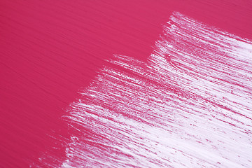 Image showing Brush strokes of white paint across a pink surface