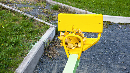 Image showing Bundle of maple leaves on sit of children teeter