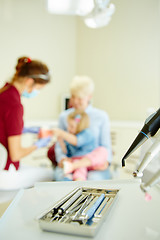 Image showing Pediatric dentist explaining to young patient and her mother the model