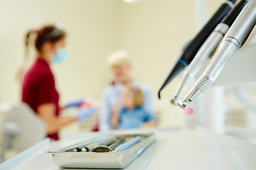 Image showing Pediatric dentist explaining to young patient and her mother the model