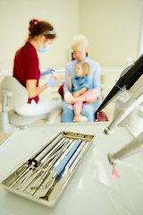 Image showing Pediatric dentist explaining to young patient and her mother the model