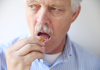 Image showing man taking fish oil pill 