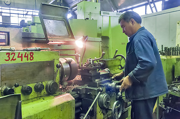 Image showing Milling-machine operator works at machine