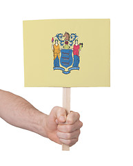 Image showing Hand holding small card - Flag of New Jersey