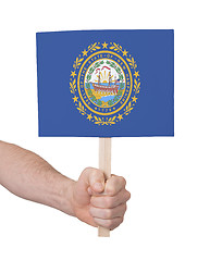 Image showing Hand holding small card - Flag of New Hampshire