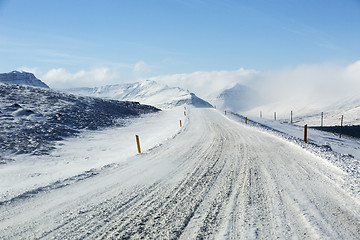 Image showing Snowy and icy road with volcanic mountains in wintertime