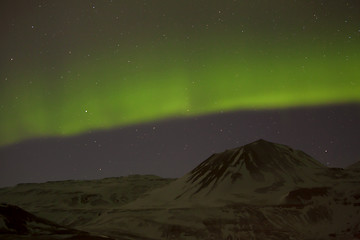 Image showing Northern lights with snowy mountains in the foreground