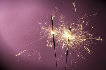 Image showing Burning sparklers on pink background