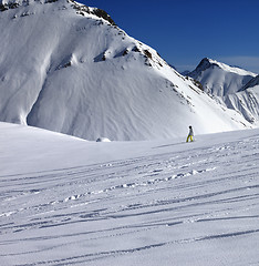 Image showing Snowboarder downhill on off piste slope with newly-fallen snow