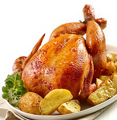 Image showing roasted chicken with potatoes on white plate