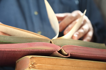 Image showing man looks through books   