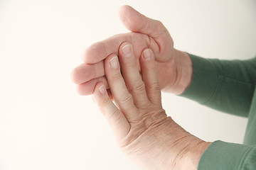 Image showing man flexing fingers against hand	