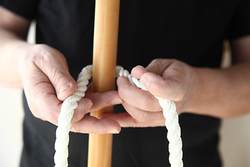 Image showing man with rope and wood pole