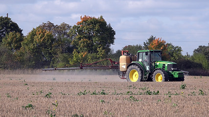 Image showing Tractor spraying stubble field with herbicide chemicals in autumn 