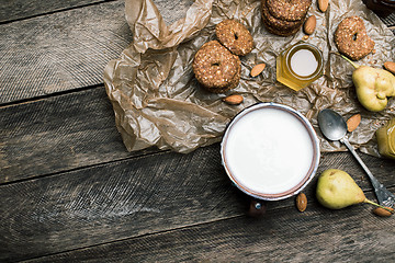 Image showing Almonds pears Cookies and milk on wooden table