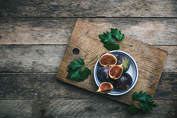 Image showing Ripe Figs on cutting board and wooden table
